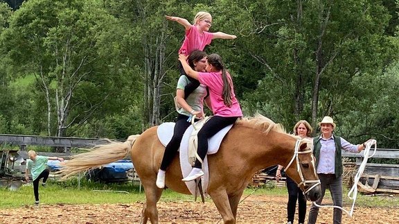 Mädchen turnen auf Pferd
