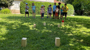 Bild zeigt Kinder bei der Freizeit 5 days, die auf einer Wiese Wikingerschach spielen.