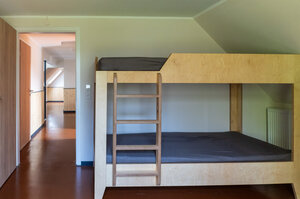 ein breites Doppelstockbett mit einer Leiter und Blick in den weiteren Flur.