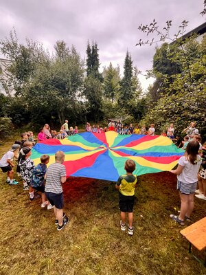 Kinder mit Fallschirmtuch