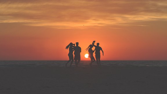 Jugendliche am Strand im Sonnenuntergang
