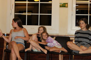 Auf dem Bild sind 4 Menschen zu sehen. Zwei Jugendliche Mädels und seine jüngere Mädels, die sich im Arm liegen. 